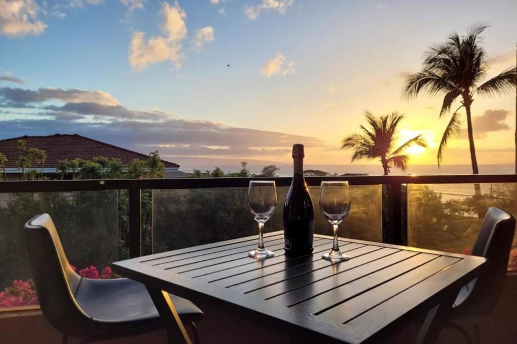 Terrasse avec 2 verres et une bouteille de vin dans une location de vacances à Maui