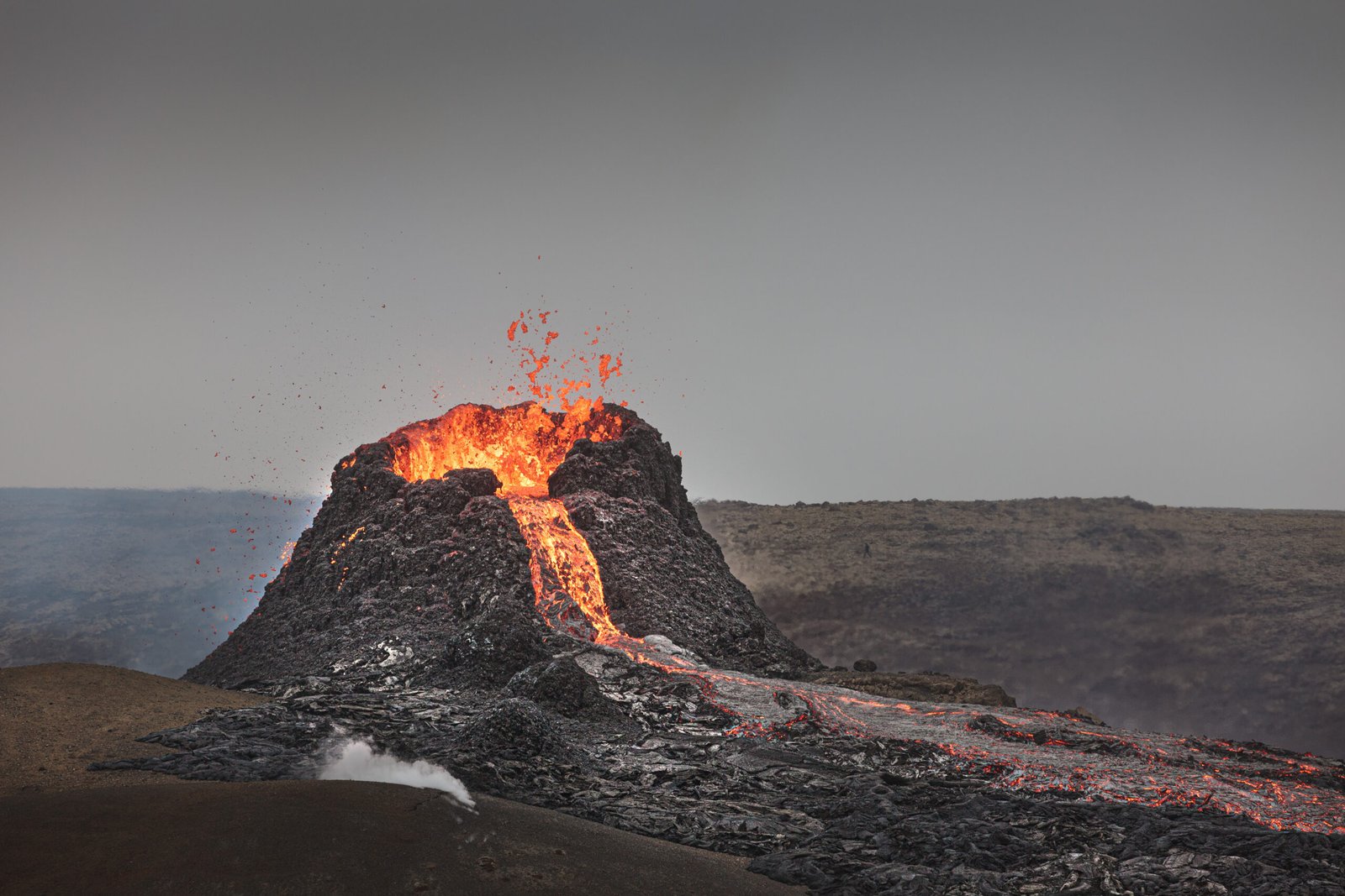 Éruption du volcan Kīlauea à Big Island, Hawaï : lave en fusion s’écoulant sur un paysage volcanique spectaculaire.