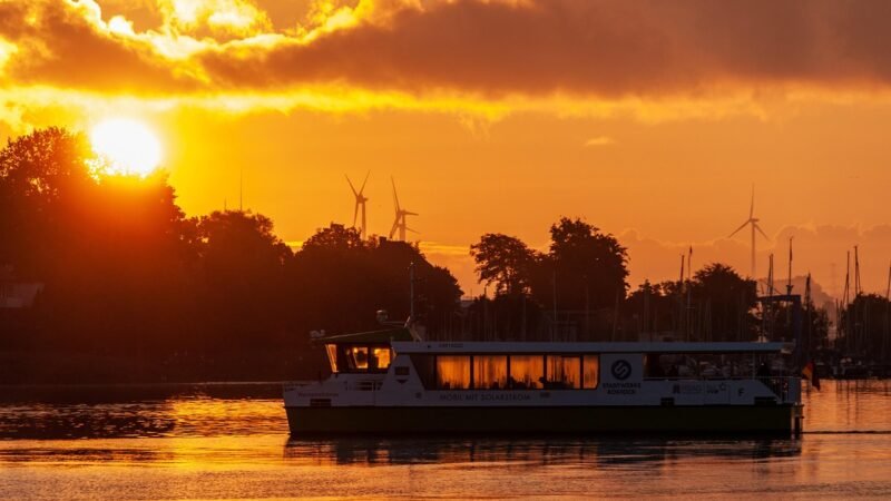 Bateau à fond de verre glissant sur une mer calme au coucher du soleil.