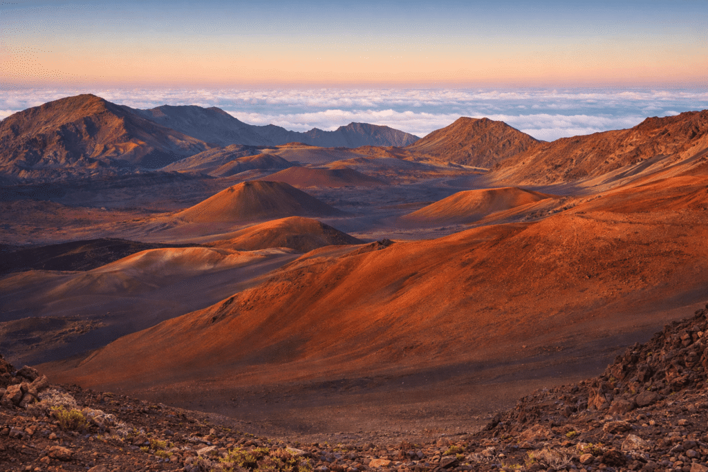 Vue détaillée des cônes volcaniques aux teintes rouge et ocre qui parsèment le cratère Haleakalā, témoins de l’histoire géologique et volcanique unique de Maui.