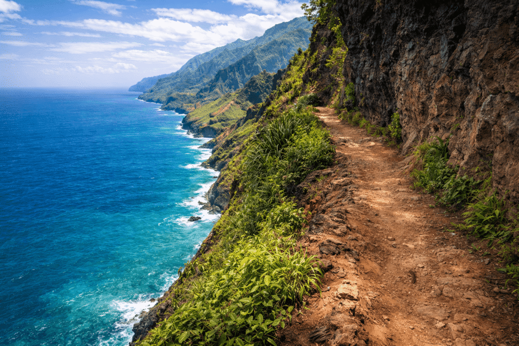 Passage étroit et exposé du Kalalau Trail avec vue directe sur l’océan Pacifique, soulignant la prudence requise sur certaines sections du sentier.