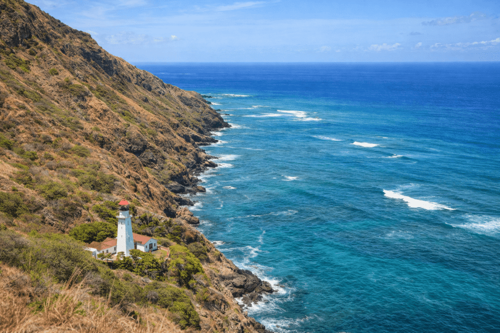 Vue en paysage du phare de Diamond Head situé sur la côte sud-est d’Oahu, avec falaises volcaniques, océan Pacifique et absence de constructions touristiques immédiates.
