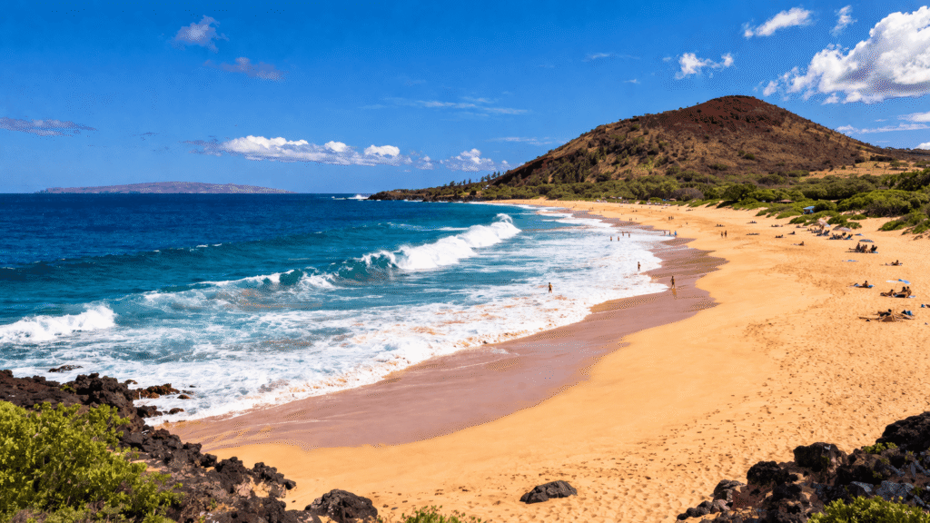 La vaste plage de Big Beach à Makena près de Wailea avec son sable doré, ses vagues puissantes et le cône volcanique Pu'u Ola'i