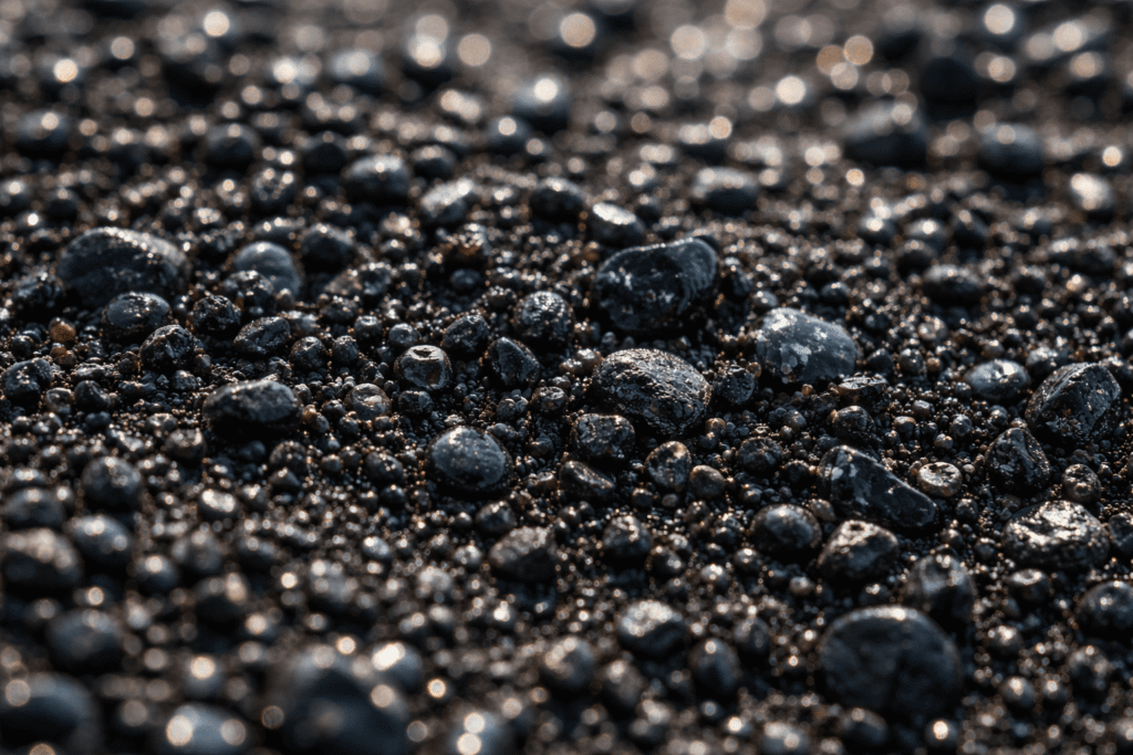 Macro photographique de grains de sable volcanique noir composés de fragments de basalte et d’obsidienne sur une plage d’Hawaï.