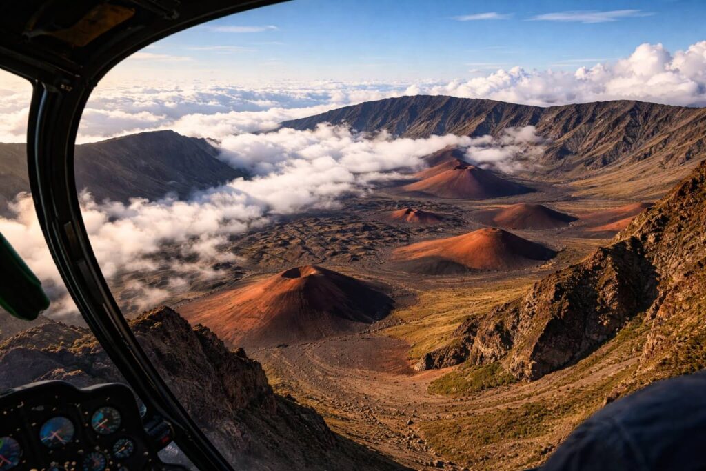 Vue aérienne du cratère lunaire du Haleakala à Maui avec cônes de cendres rouges et nuages depuis un hélicoptère
